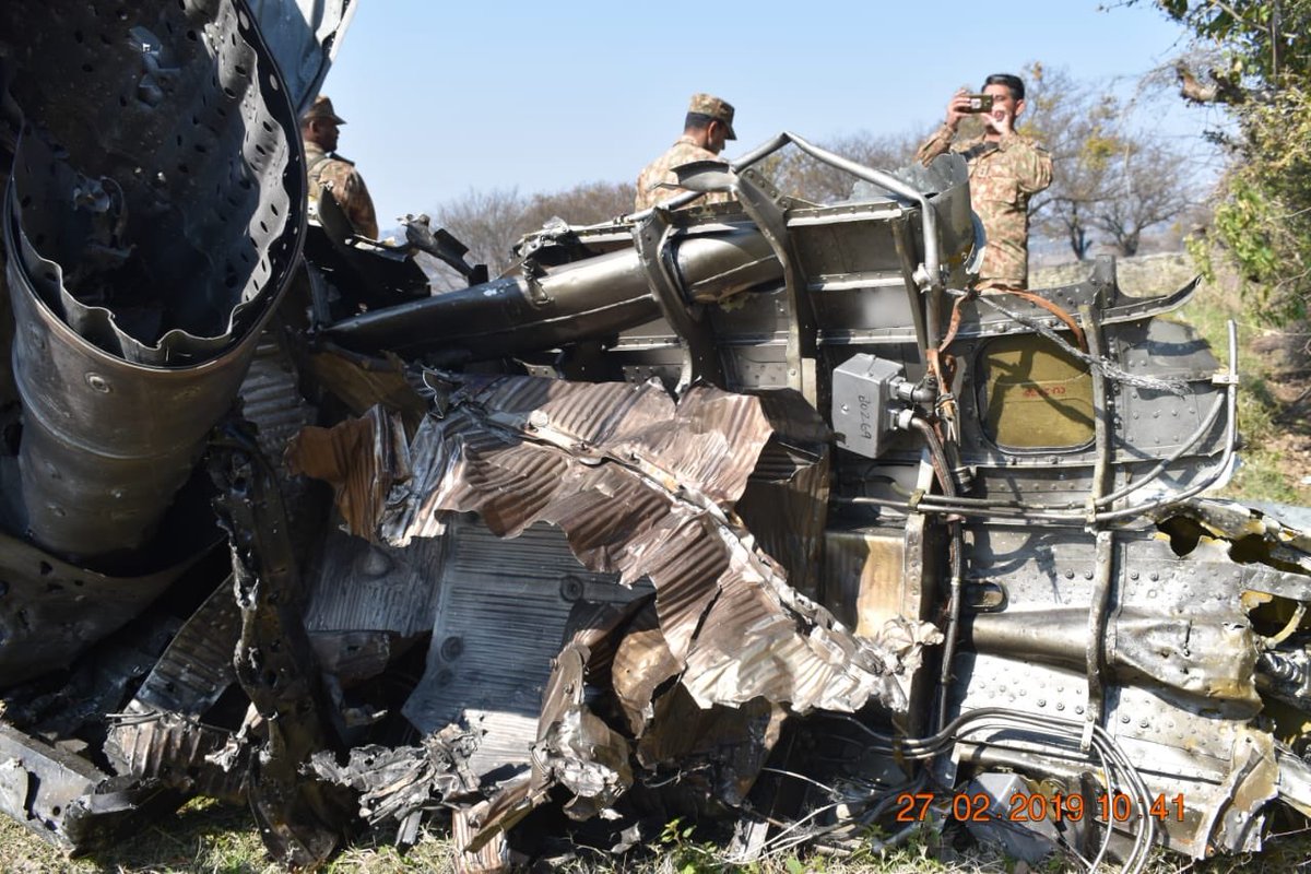 Pakistan army releases images of a downed Indian jet and documents/guns recovered from the captured pilots.   